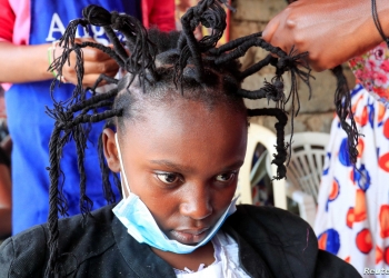 Martha Apisa, 12, gets plaited with the "coronavirus" hairstyle, designed to emulate the prickly appearance of the virus under a microscope, as a fashion statement against the spread of the coronavirus disease (COVID-19), at Mama Brayo Beauty Salon within Kambi-Muru village of Kibera slums in Nairobi, Kenya April 29, 2020. Picture taken April 29, 2020. REUTERS/Thomas Mukoya