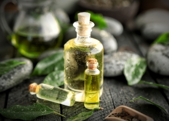 Spa composition with tea oil in glass bottles and fresh leaves