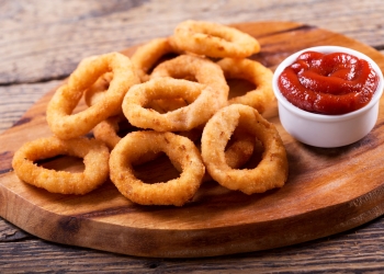 onion rings with ketchup on wooden board