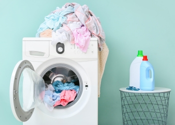 Washing machine with dirty clothes and detergents in home laundry room