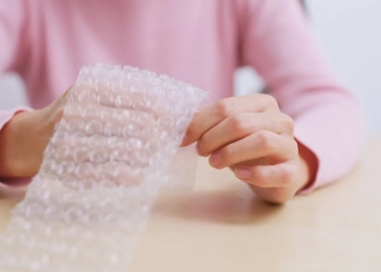 Woman play with bubble wrap to relief stress