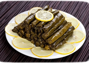 Dolma on white plate with lemon. Dolma is a dishes in the cuisines of the former Ottoman Empire. İt's include onion, zucchini, eggplant, tomato and pepper. The stuffing may or may not include meat.