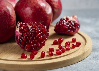 Sliced ripe pomegranate on a wooden board. High quality photo