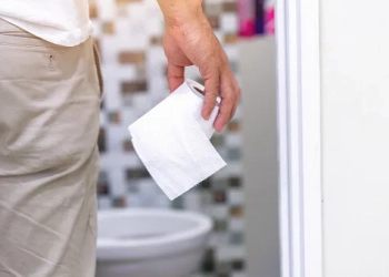 Man's hand, he holds a roll of toilet paper Going to the bathroom Toilet toilet background
